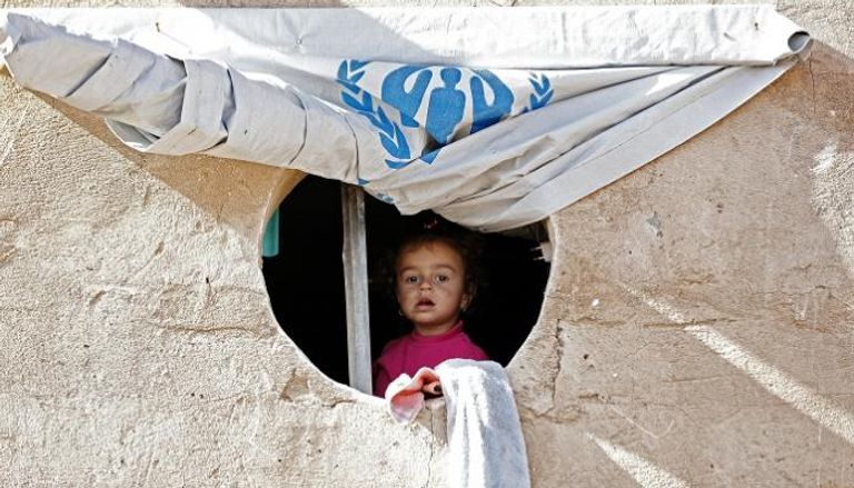 طفلة عراقية بمخيم للنازحين تنظر إلى المجهول