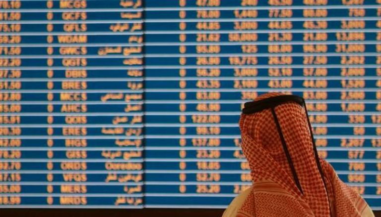 متداول يستعرض أسعار الأسهم في بورصة الدوحة عاصمة قطر - رويترز