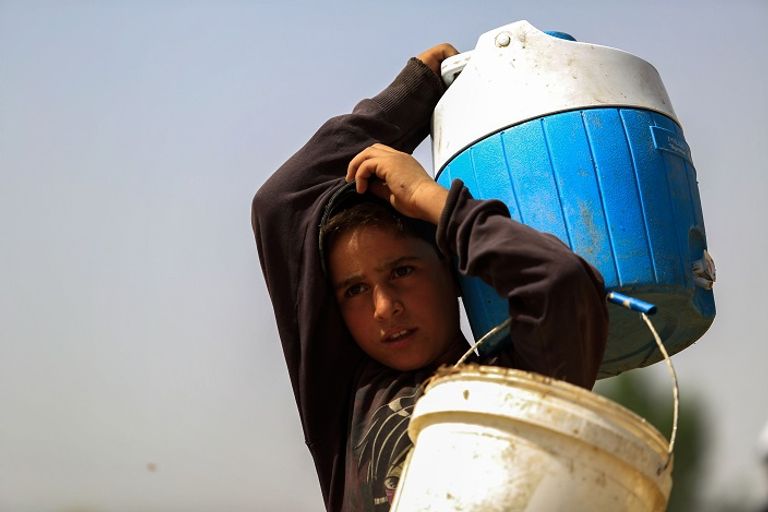 طفلة سورية تروي ظمأها من المياة