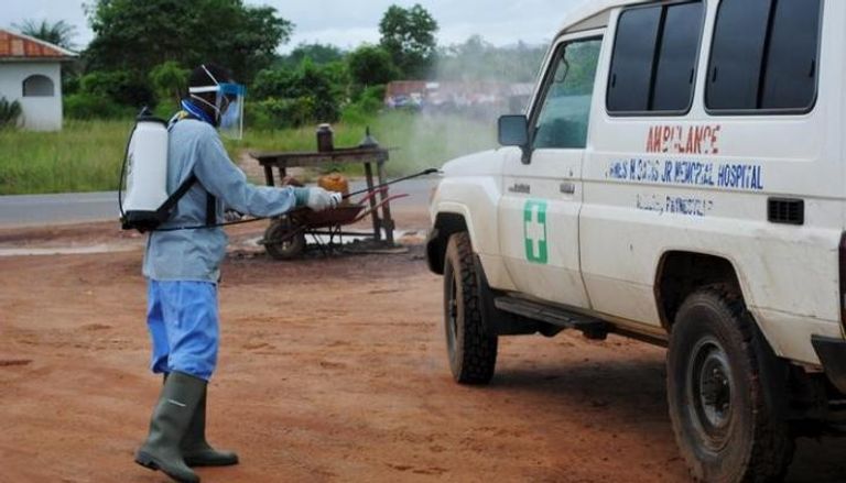 عامل يرش مبيدا على سيارة إسعاف في ليبيريا