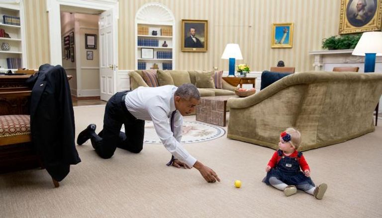 أوباما يلاعب ابنة موظفة بالبيت الأبيض