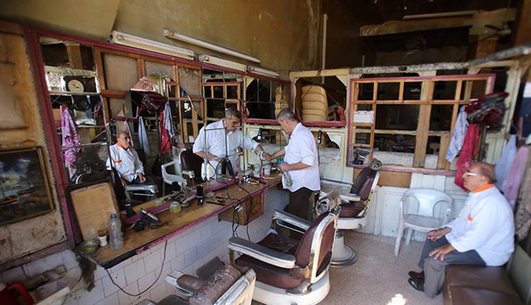 حلاق ينظف متجره في المناطق التي تسيطر عليها الحكومة من السوق القديم التاريخي في حلب القلعة المدرجة في قائمة اليونسكو  في الجانب الذي تسيطر عليه الحكومة في حلب الشمالية