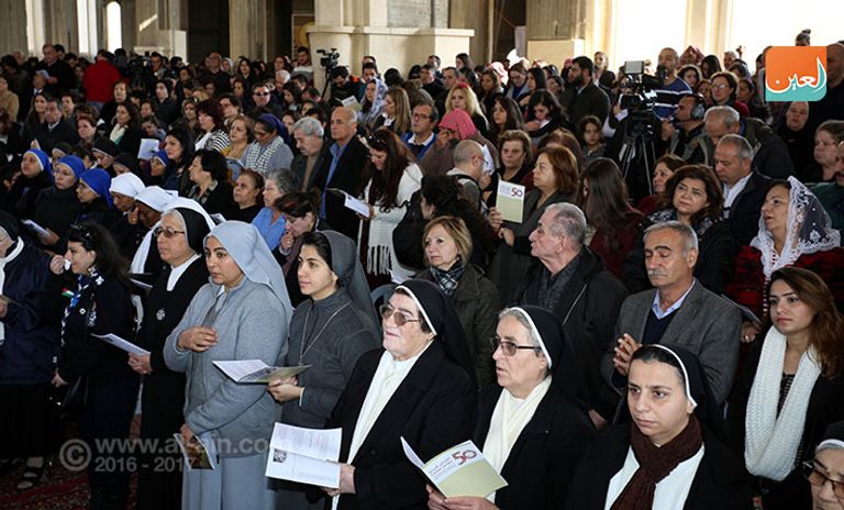 حجاج يؤدون المناسك في الكنيسة الكاثوليكية بالأردن