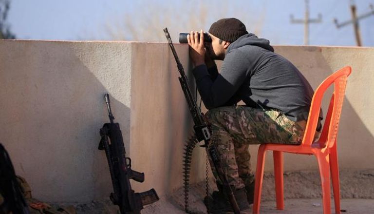 جندي عراقي يراقب مواقع داعش بالموصل