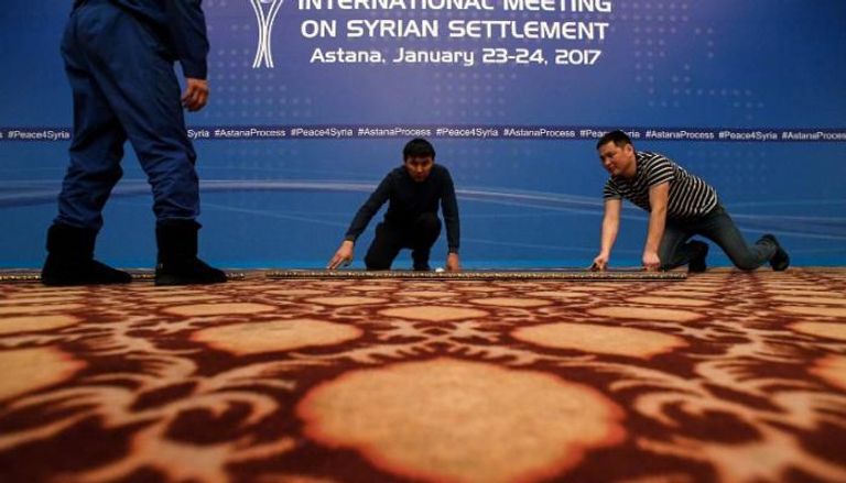 عمال يفترشون الأرض استعدادا لمحادثات سوريا في أستانة - أ ف ب