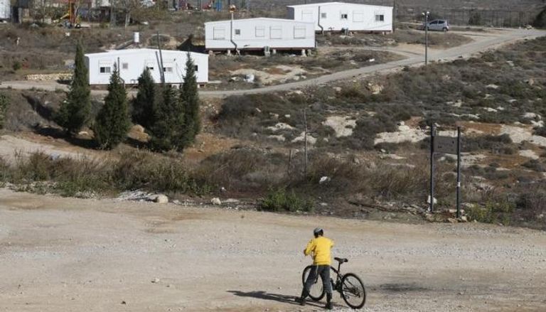 صبي إسرائيلي يمسك بدراجة قرب مستوطنة عمونا بالضفة الغربية