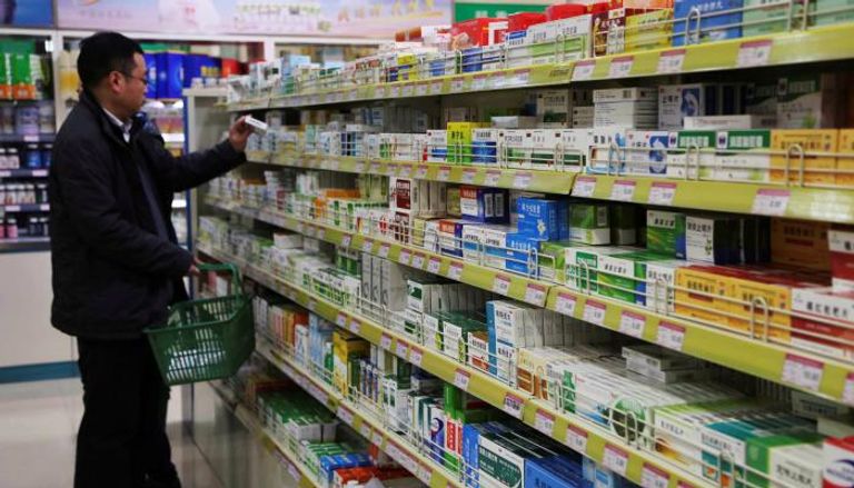 صينيون يشترون أدوية من إحدى الصيدليات