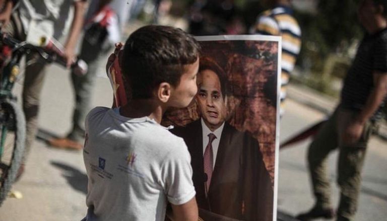 طفل من غزة يقبل صورة الرئيس السيسي