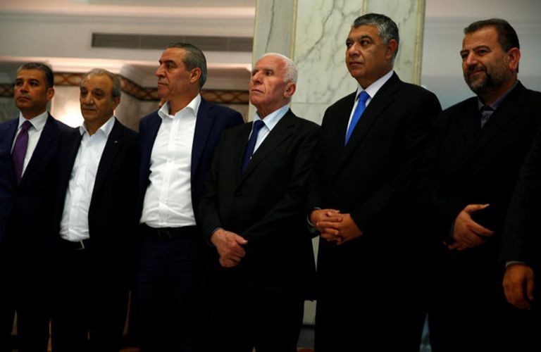 قيادات من المخابرات المصرية مع القيادات الفلسطينية خلال توقيع الاتفاق توقيع الاتفاق بين فتح وحماس برعاية مصرية في القاهرة (رويترز)