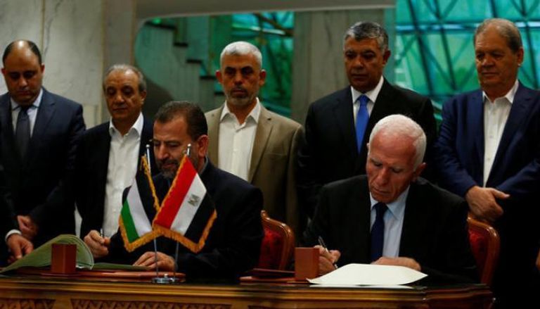 رئيسا وفدي فتح وحماس خلال توقيع الاتفاق بالقاهرة (رويترز)
