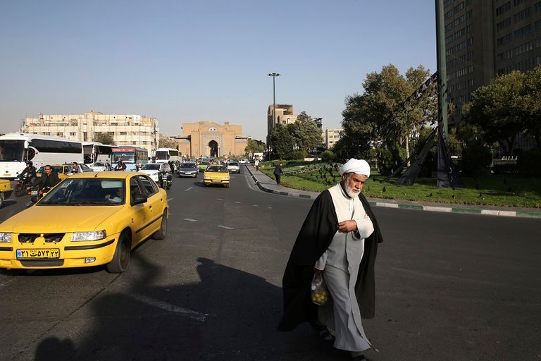مسن إيراني يحمل الصحف بالعاصمة طهران