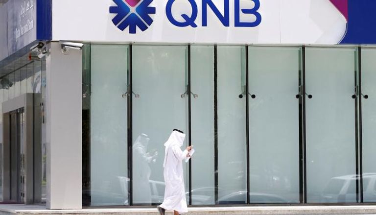 رجل أمام بنك قطر الوطني
