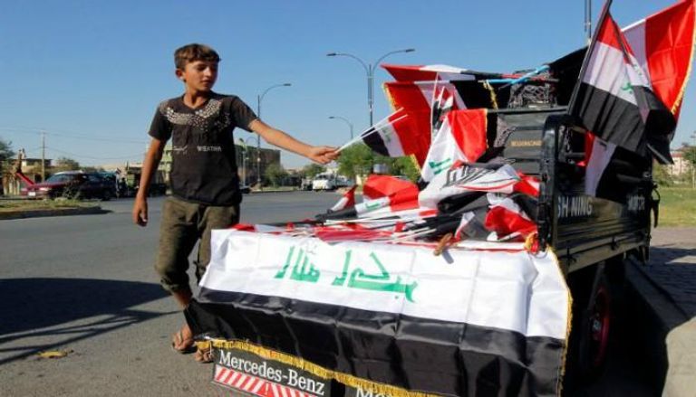 طفل يبيع أعلام العراق في شوارع كركوك-رويترز