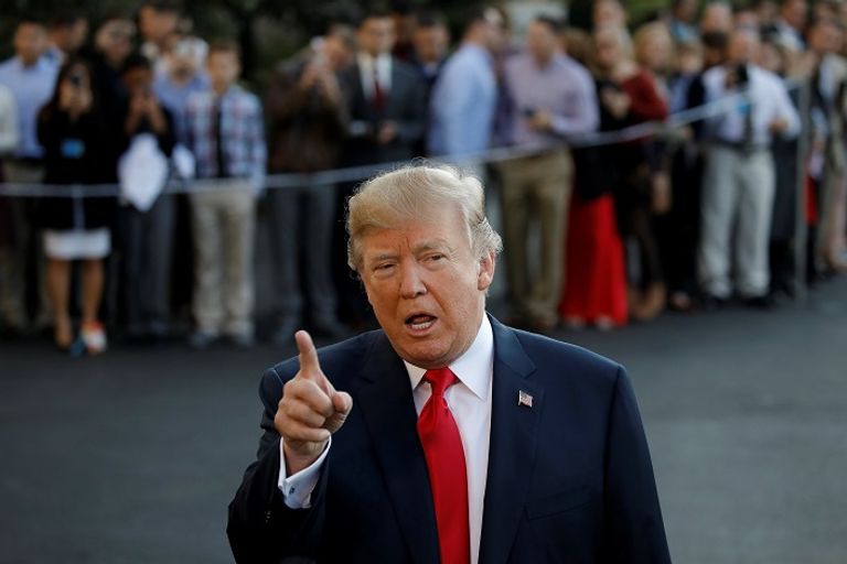 الرئيس الأمريكي ترامب وفي الخلفية يجلس تيلرسون - رويترز