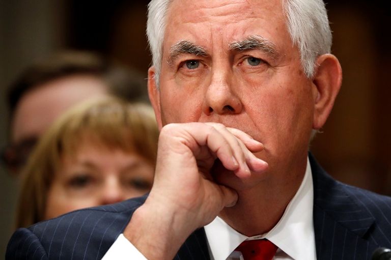 الرئيس الأمريكي ترامب وفي الخلفية يجلس تيلرسون - رويترز