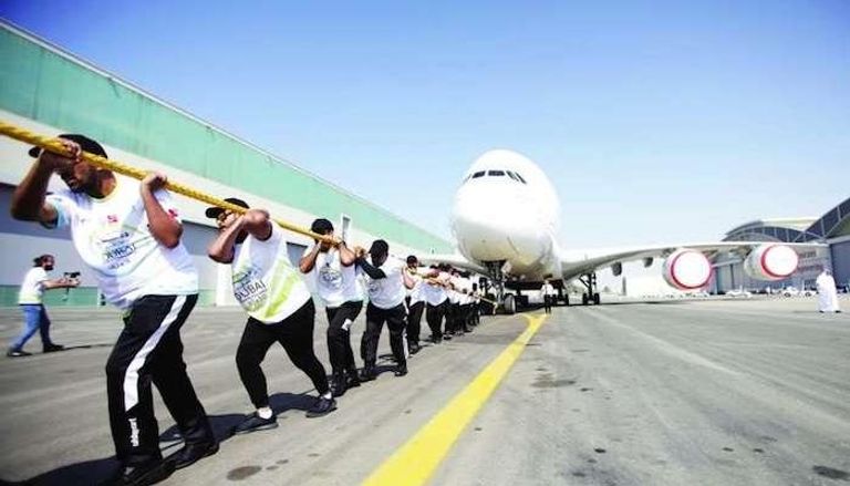 افراد شرطة دبي يسحبون الطائرة