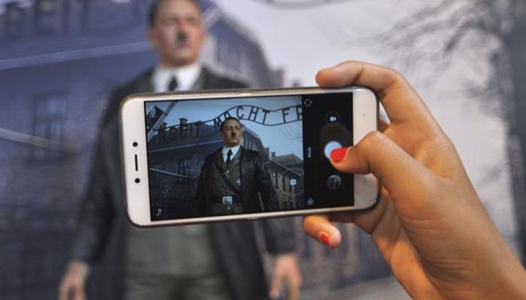 زائرة بالمتحف تلتقط صورة لتمثال هتلر