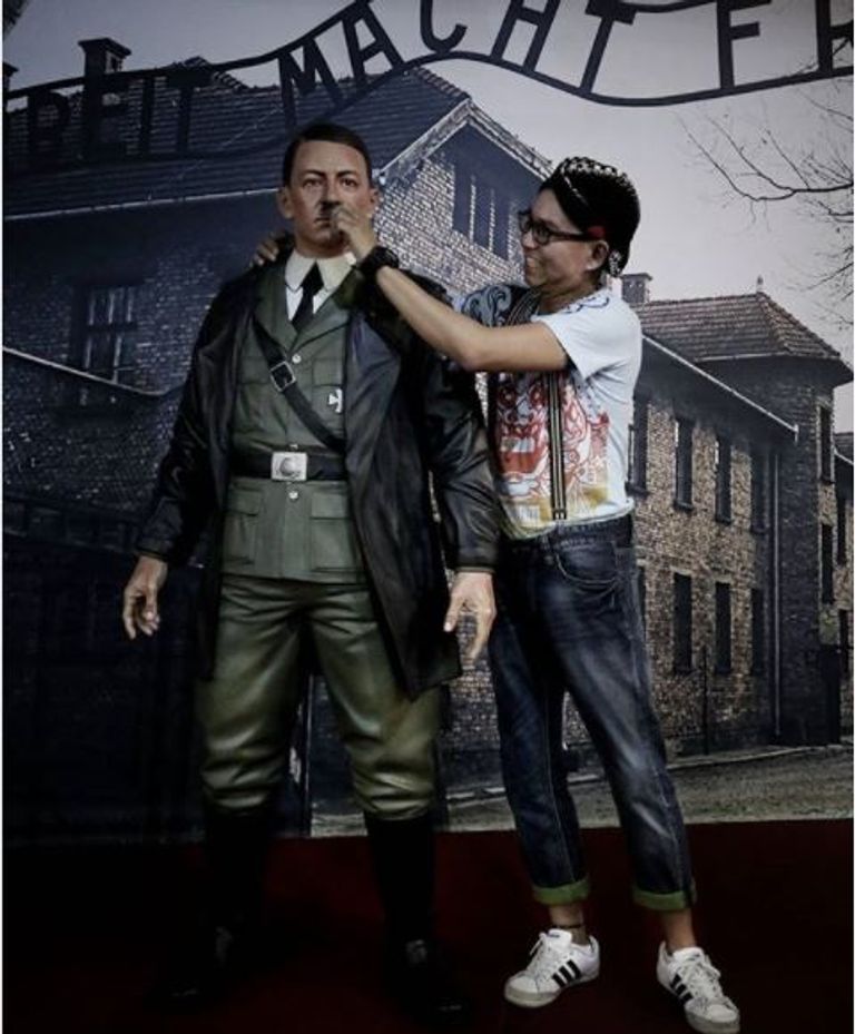 زائرة بالمتحف تلتقط صورة لتمثال هتلر