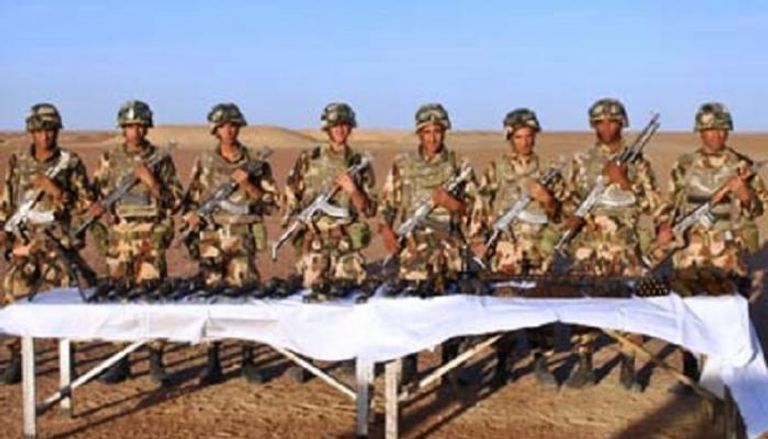 جنود الجيش الجزائري أمام الأسلحة التي تم العثور عليها
