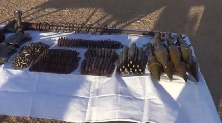 جنود الجيش الجزائري أمام الأسلحة التي تم العثور عليها