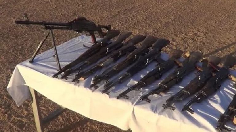 جنود الجيش الجزائري أمام الأسلحة التي تم العثور عليها