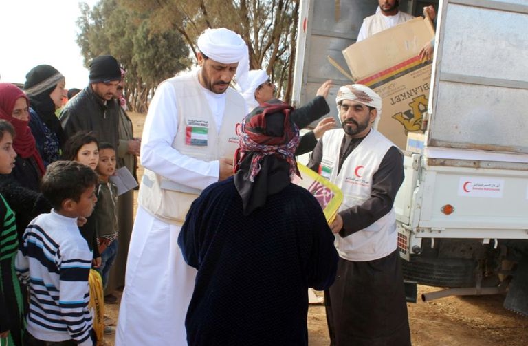 أفراد الهلال الأحمر يوزعون المستلزمات