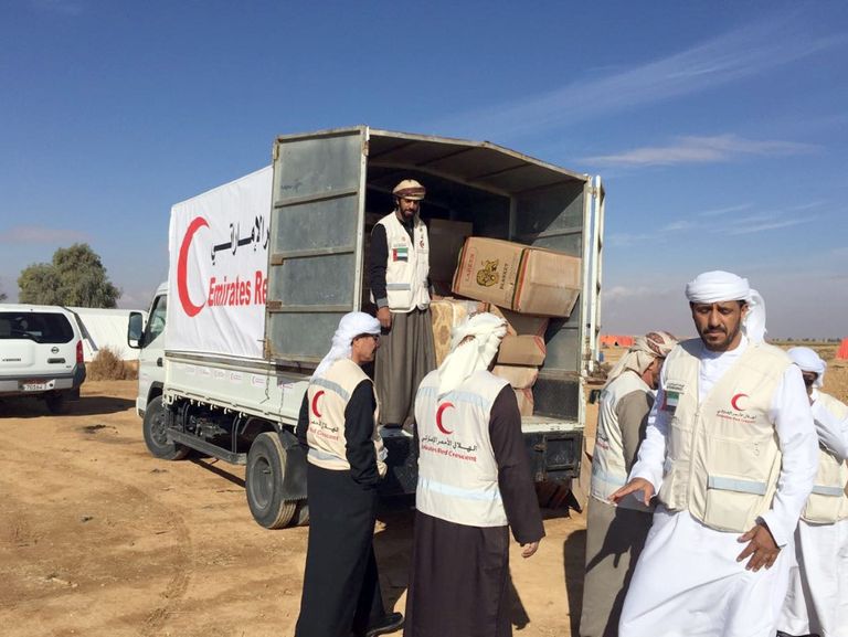 أفراد الهلال الأحمر يوزعون المستلزمات