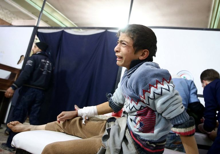 طفل سوري يبحث عن بقايا أثاث منزله تحت الحطام - رويترز