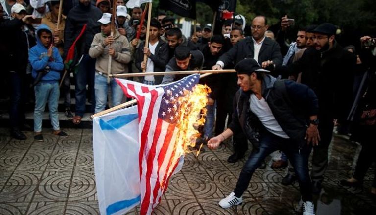 فلسطينيون يشعلون النار في علمي أمريكا وإسرائيل بغزة - رويترز