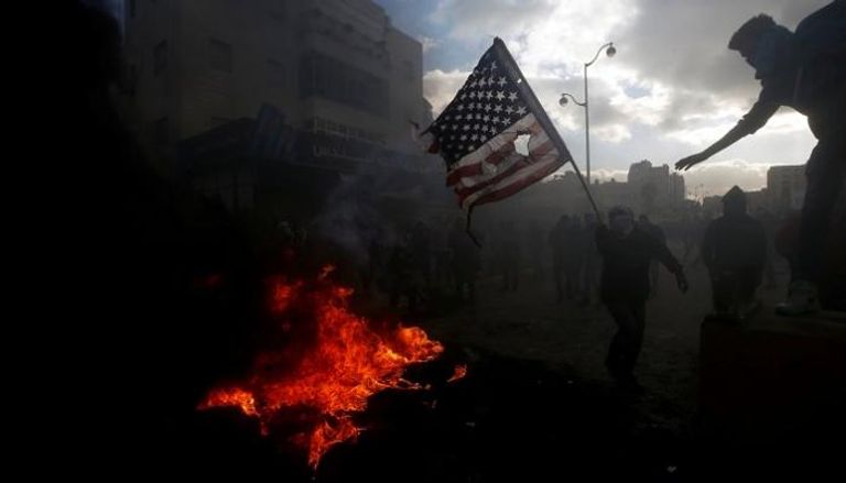 الفلسطينيون يحرقون العلم الأمريكي احتجاجا على قرار ترامب