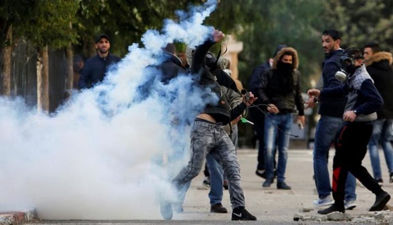 شباب فلسطينيون يواجهون قنابل الغاز الإسرائيلية