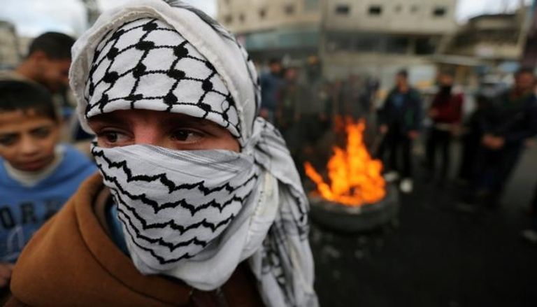 فلسطيني في مواجهات مع الاحتلال (رويترز)