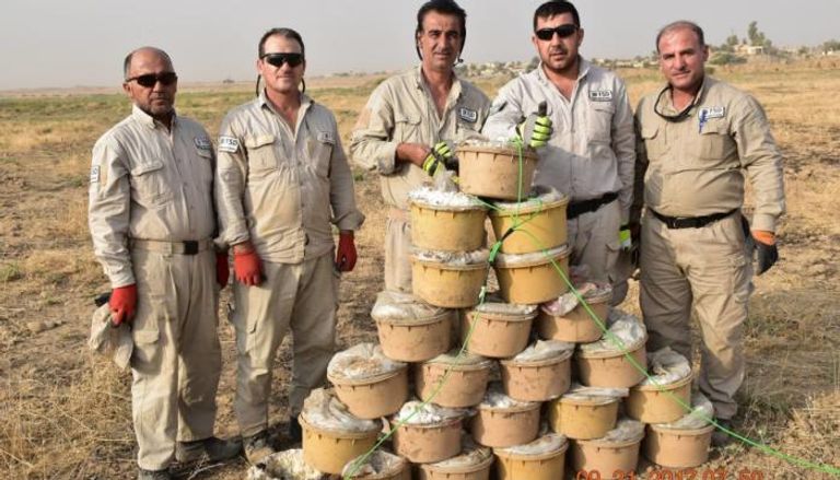 حفارون أكراد أمامهم ألغام في عبوات بلاستيكية اخترعها "داعش"