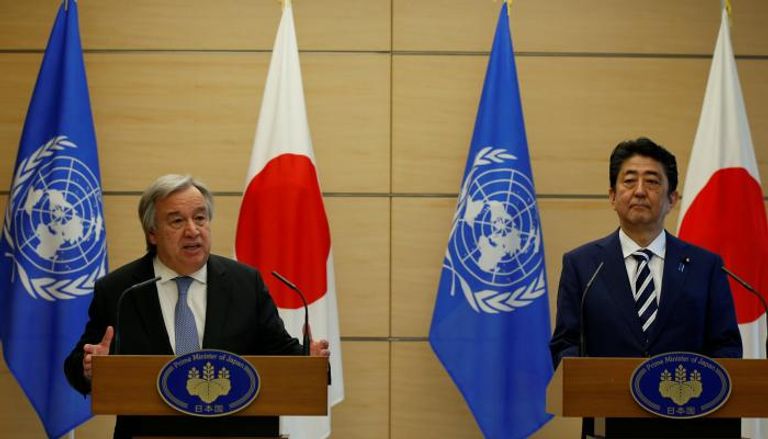 الأمين العام للأمم المتحدة جوتيريس ورئيس الوزراء الياباني أبي (رويترز)