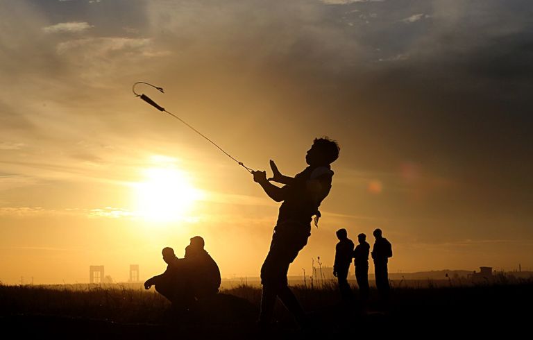 شاب فلسطيني يحمل مقلاعا ويقذف جنود الاحتلال بالحجارة مواجهات نصرة للقدس شرق غزة