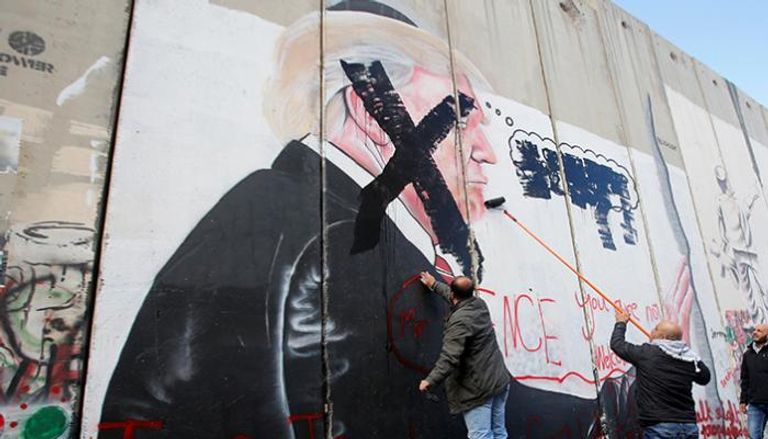 صورة للرئيس الأمريكي  على أحد الجدران العازلة الإسرائيلية (رويترز)