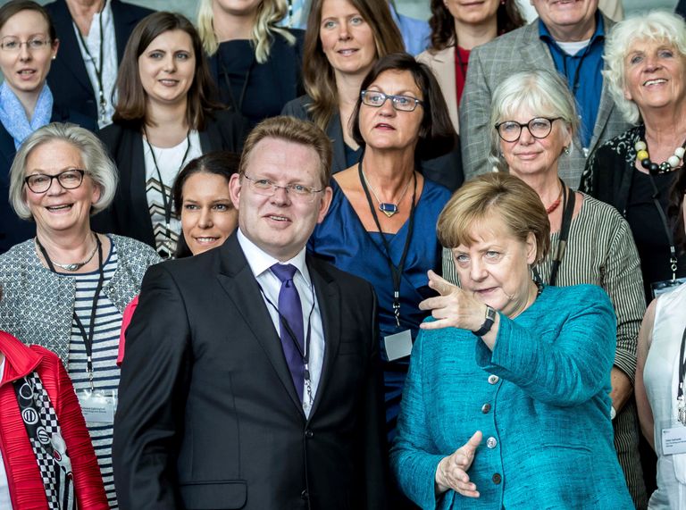 العمدة أندرياس هولستين والمستشارة انجيلا ميركل العمدة أندرياس هولستين ويبدو في رقبته أثر الهجوم