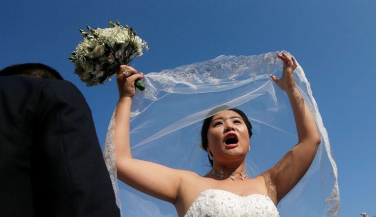 عروسة تعبر عن فرحتها بالزفاف تنشيط السياحة في سريلانكا بحفل زفاف جماعي للصينيين