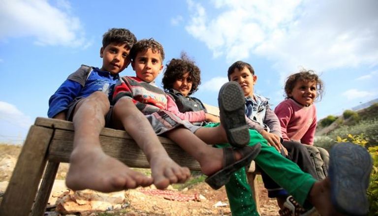 أطفال سوريون في مخيم للاجئين قرب الحدود اللبنانية - رويترز 