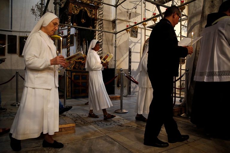 مصلون في كنيسة المهد بالضفة الغربية 19 ديسمبر - رويترز مواجهات بين فلسطينيين وقوات الاحتلال في بيت لحم- رويترز