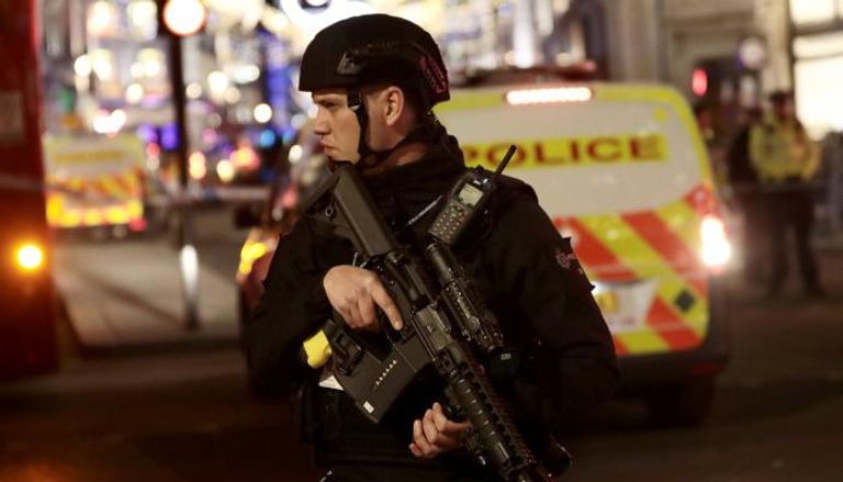 عنصر أمن بريطاني يحمل سلاحا أمريكيا من طراز M4 (رويترز)