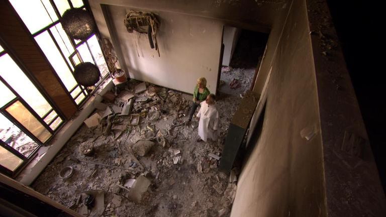 الأب "نجيب ميخائيل" خلال عرضه لأحد الكتب المتضررة