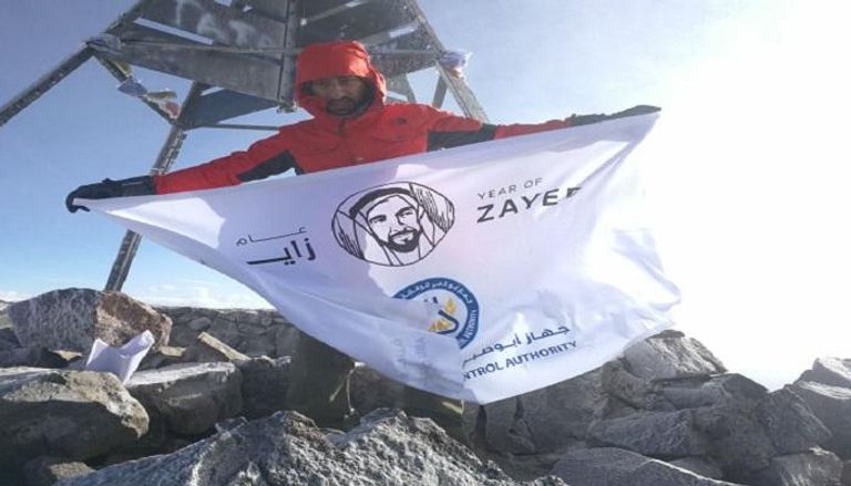 المغامر الإماراتي راشد اليافعي يرفع شعار عام زايد على قمة جبل 