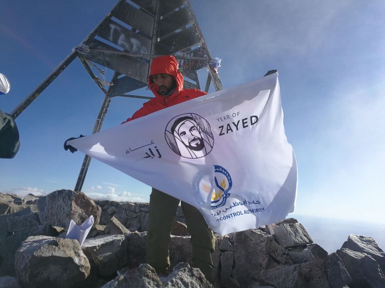 المغامر الإماراتي راشد اليافعي يرفع شعار عام زايد على قمة جبل