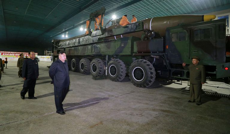 زعيم كوريا الشمالية كيم حونج اون يتفقد أحد الصواريخ قبل التجارب أحد المارة يشاهد تجربة صاروخ بالستي كوري شمالي في شارع بطوكيو (رويترز)