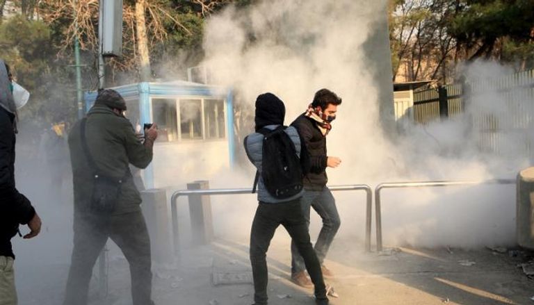 متظاهرون يتعرضون لقنابل الغاز من جانب الشرطة الإيرانية - الفرنسية 