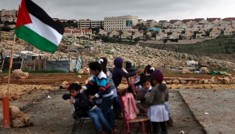 أطفال فلسطينيون أمام مستوطنة إسرائيلية