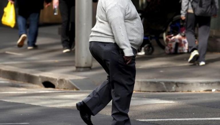 رجل بدين يعبر طريقا في وسط سيدني بأستراليا (أرشيفية)