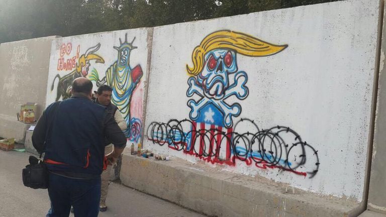 الفنان العراقي أركان البهادلي أمام الجدارية