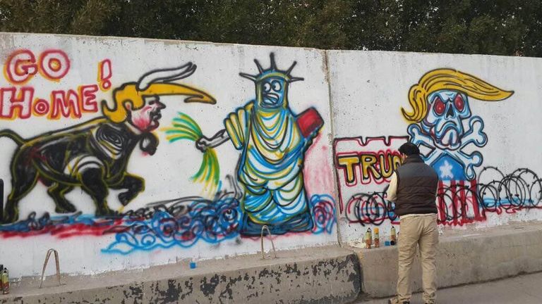 الفنان العراقي أركان البهادلي أمام الجدارية